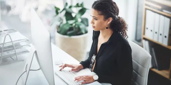 mulher mexendo no computador calculando encargos trabalhistas